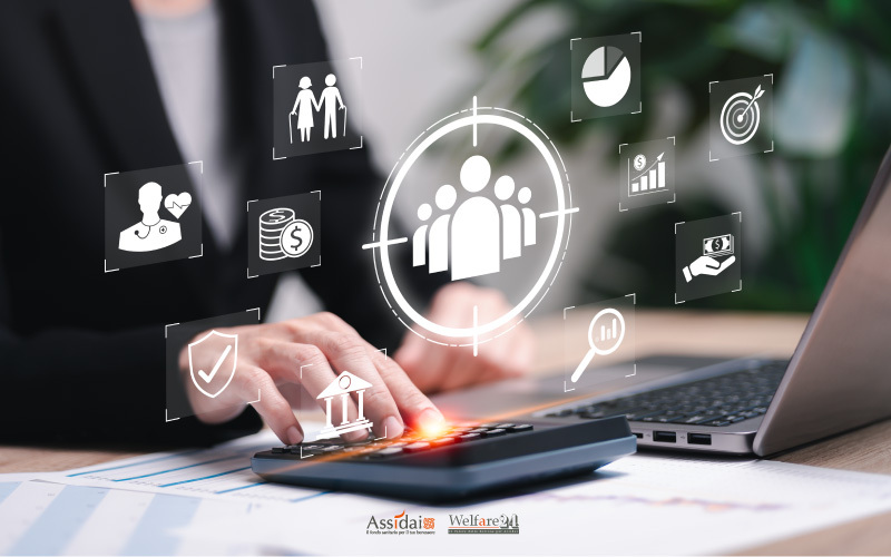 Professionista che utilizza una calcolatrice su un piano di lavoro, circondato da icone digitali che rappresentano i pilastri del welfare aziendale e la gestione dei benefit.