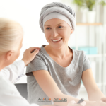 Medico che offre supporto e conforta una paziente sorridente con copricapo in studio, simbolo di cura e ricerca oncologica.