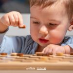 Bambino impegnato in un gioco educativo da tavolo, immagine sul tema del neurosviluppo