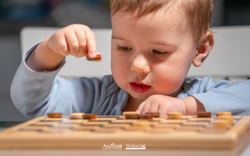 Bambino impegnato in un gioco educativo da tavolo, immagine sul tema del neurosviluppo